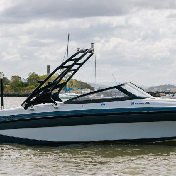 A Yamaha outboard motor speedboat with a black wakeboard tower, shown on the water under a cloudy sky.