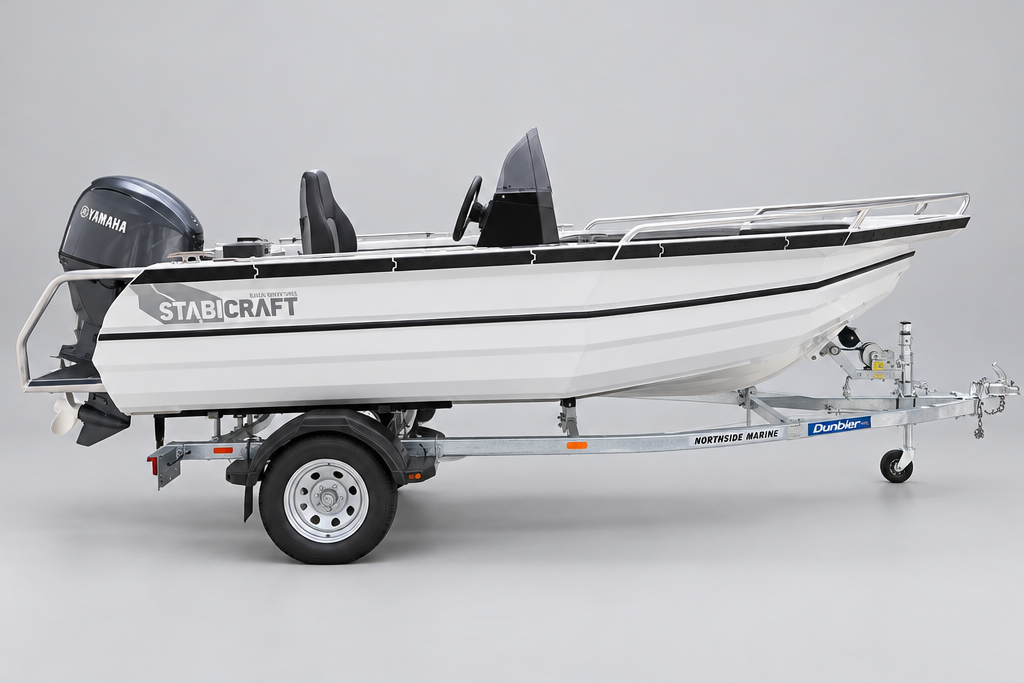 A white Stabcraft boat on a metal trailer parked in front of a Yamaha dealership building.