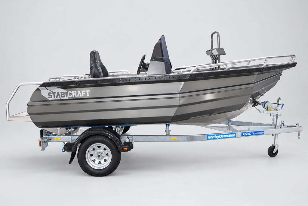 A gray and black Stabicraft motorboat on a dual-axle trailer, parked outdoors in front of a Yamaha dealership building.