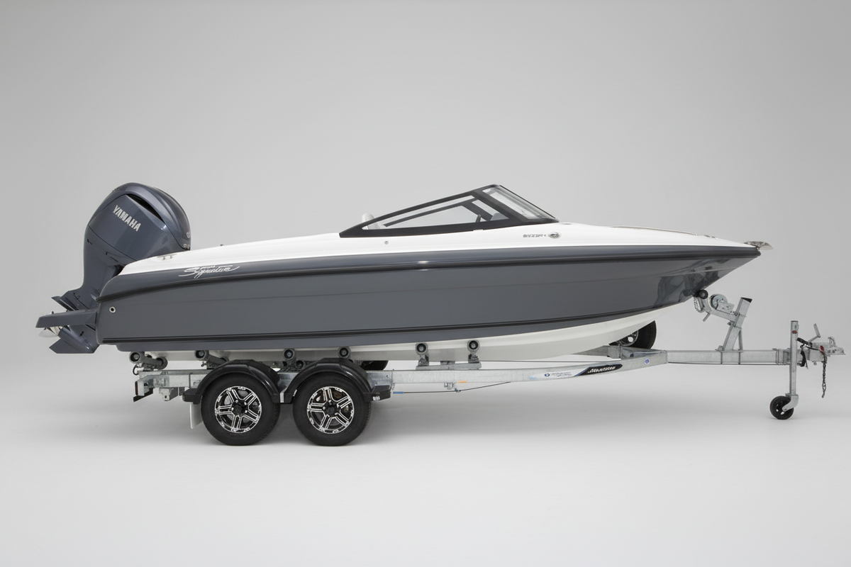 A Haines Signature 620BRX Bowrider with Yamaha outboard motor speedboat on a dual-axle trailer, parked in front of a boat dealership building with a Yamaha logo.