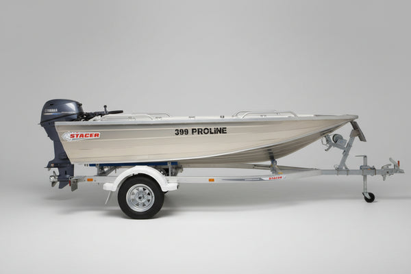 A stainless steel aluminum boat on a trailer parked in front of a boat dealership building. The boat has 'STACER' and '399 PHOLINE' printed on the side.